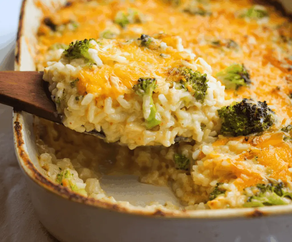 Creamy chicken broccoli rice cheese casserole in a baking dish, topped with melted cheese and fresh broccoli florets, perfect for a comforting family dinner.