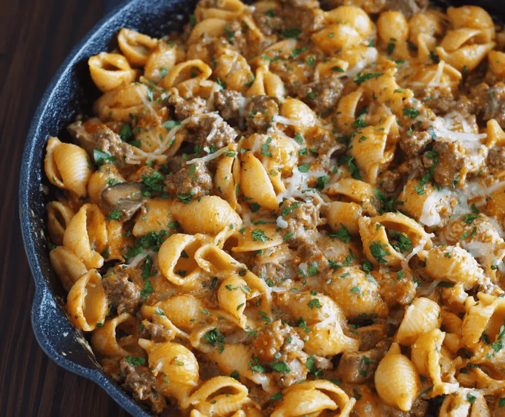 Creamy beef and shell pasta dish served in a bowl, featuring tender ground beef, pasta shells, and a rich creamy sauce garnished with herbs