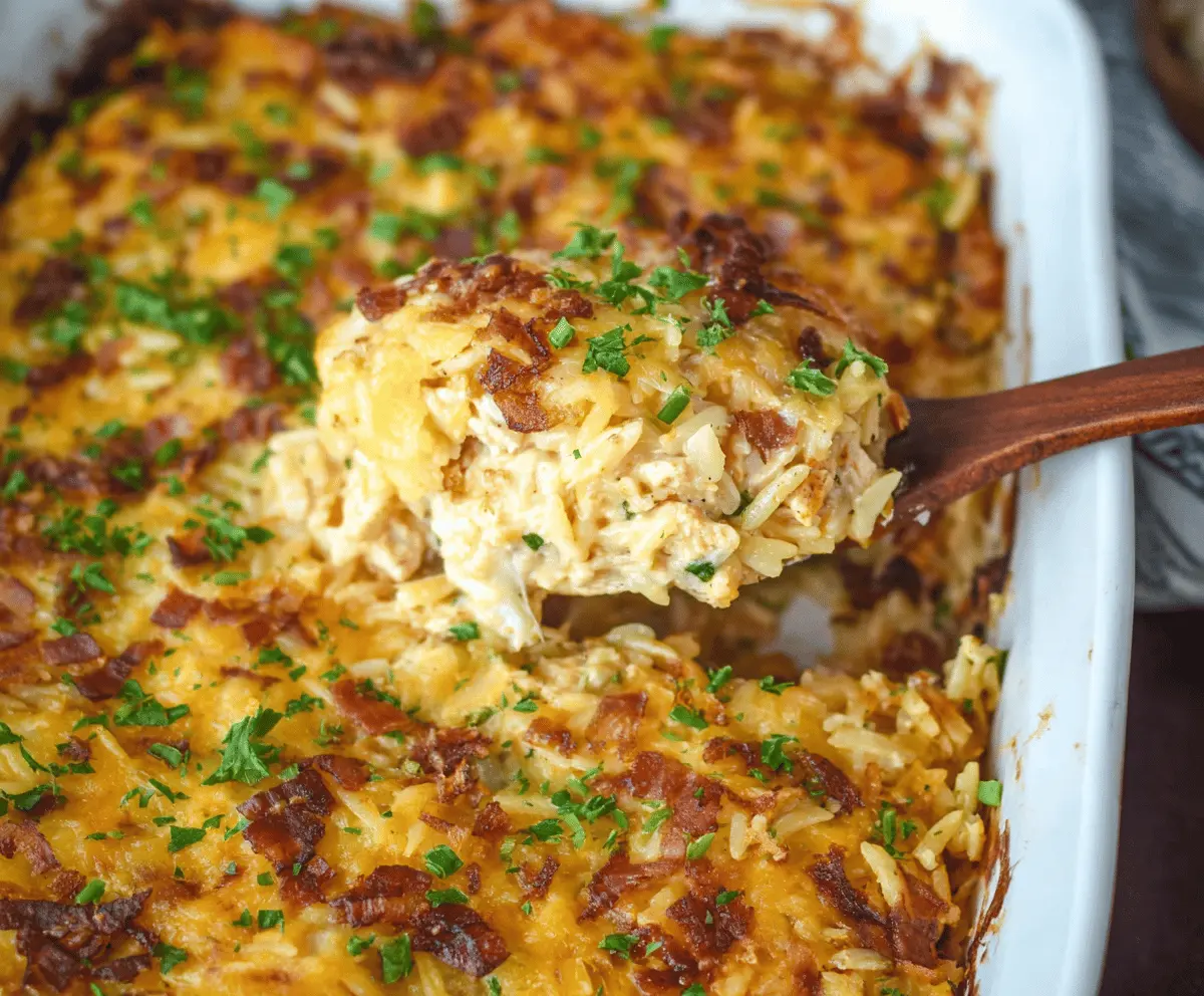 Creamy French Onion Chicken Orzo Casserole topped with melted cheese and caramelized onions, served hot in a baking dish