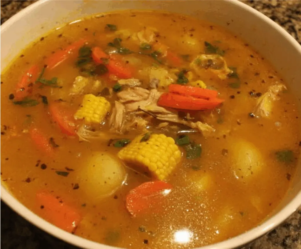 Hearty Jamaican Chicken Soup with vegetables and spices in a bowl.