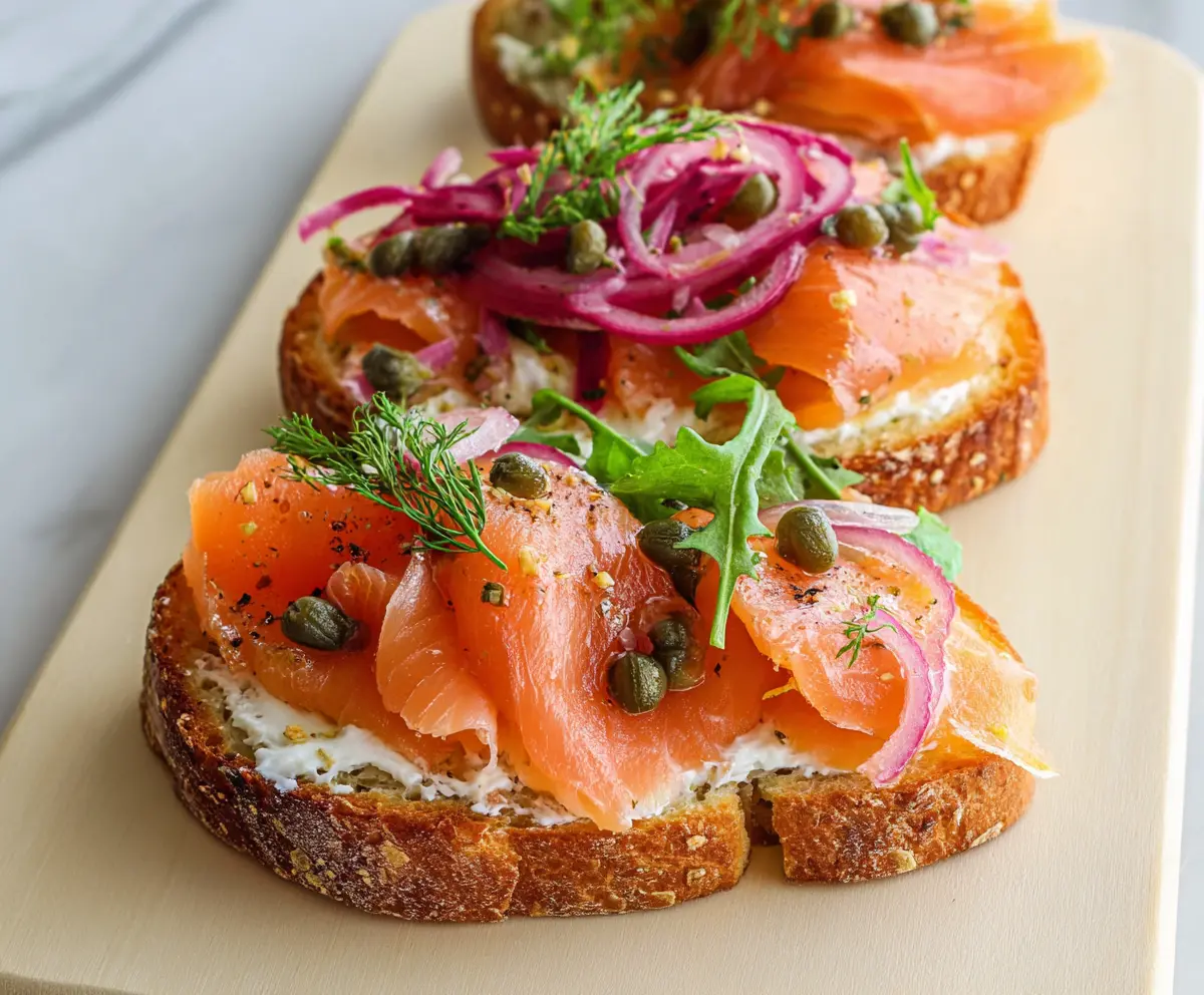 Delicious smoked salmon bruschetta topped with fresh herbs and creamy cheese, perfect for appetizer gatherings.